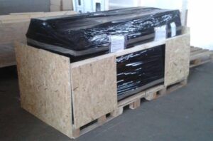 wooden crate on pallet wrapped with black plastic for shipping